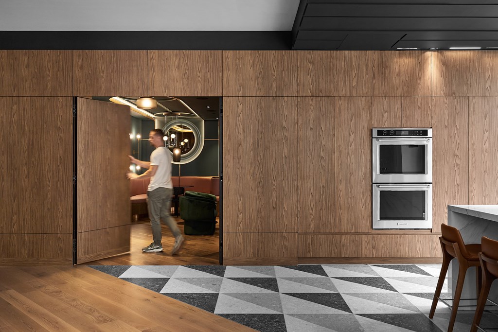 A man is walking through a doorway into a kitchen.