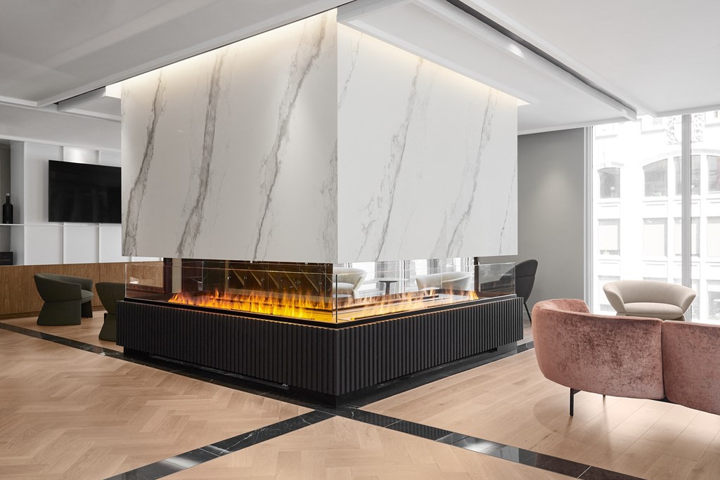 A modern living room with a fireplace and a marble wall.