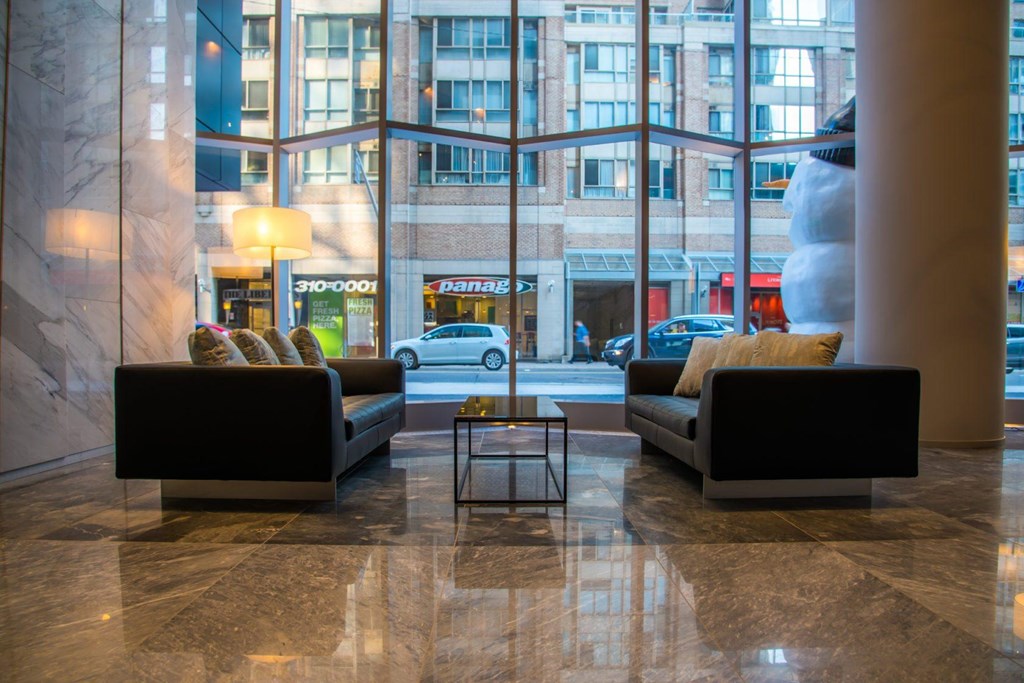 A black couch and a black coffee table in a marble room.