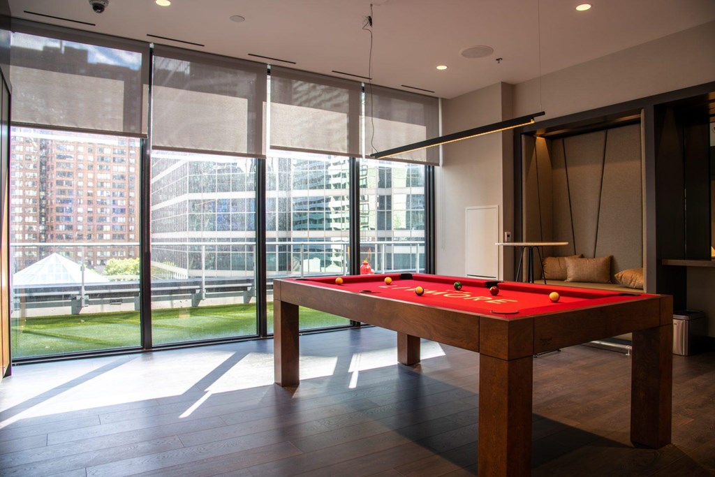 A pool table in a room with a view of the outside.