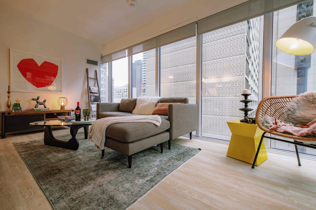 A bedroom with a large bed and a wicker chair.