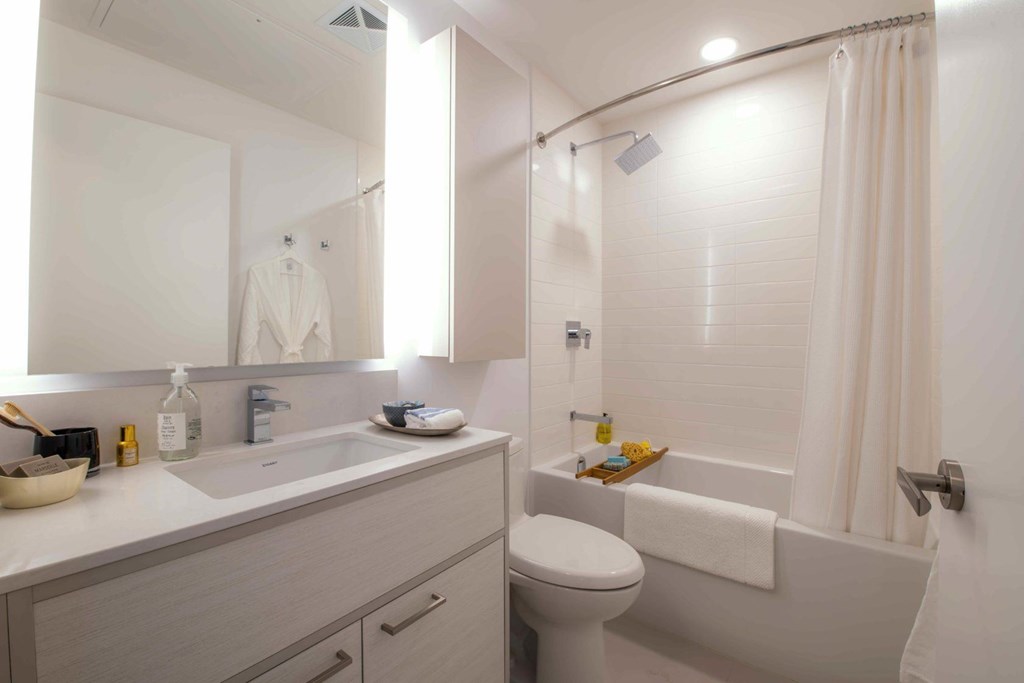 A white bathroom with a toilet, sink, and bathtub.