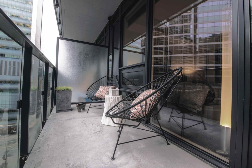 A balcony with two chairs and a table.