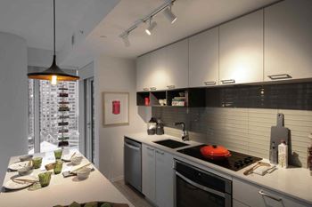 A modern kitchen with a large island and a view of a cityscape.