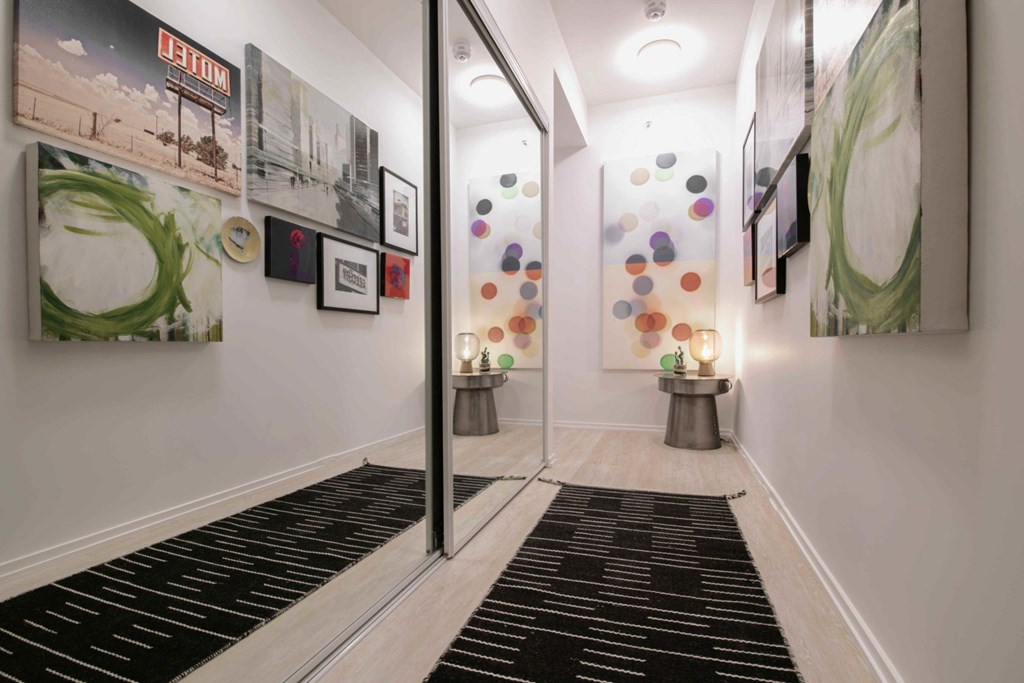 A hallway with a black and white striped rug and a wall with pictures and a sign that says "PENTIUM".