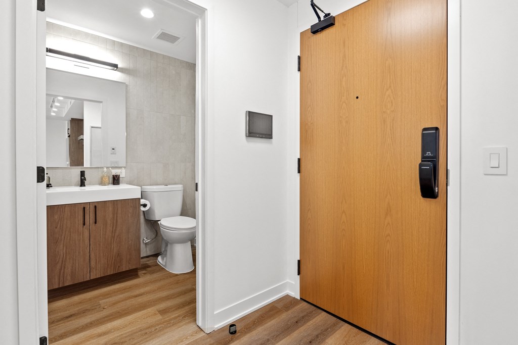 a door leading into a bathroom with a toilet and a sink