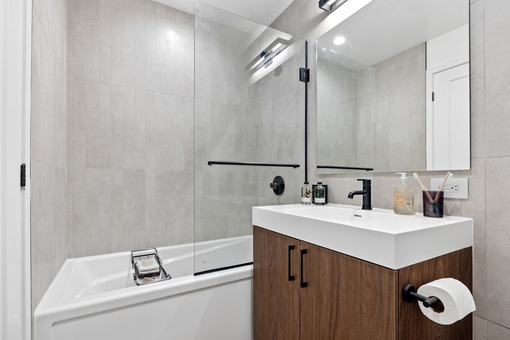 a bathroom with a sink and a shower and a mirror