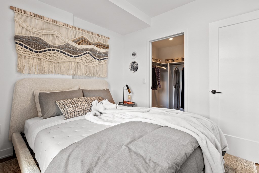 a bedroom with a bed and a door to a closet