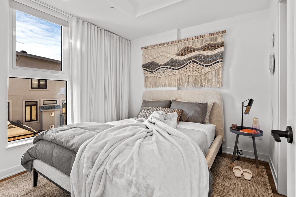 a bedroom with a bed and a large window