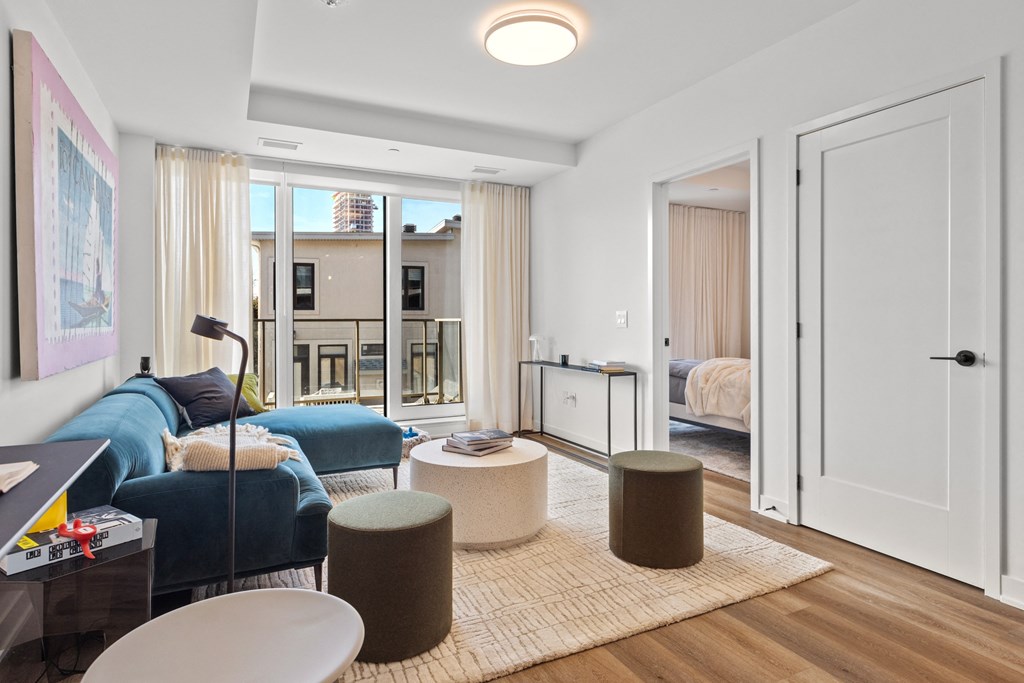 a living room with a couch and a table and a door to a bedroom