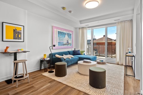 a living room with a blue couch and a large window