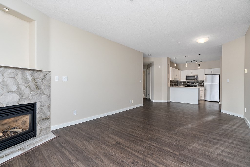 A spacious living room with a fireplace and hardwood floors.