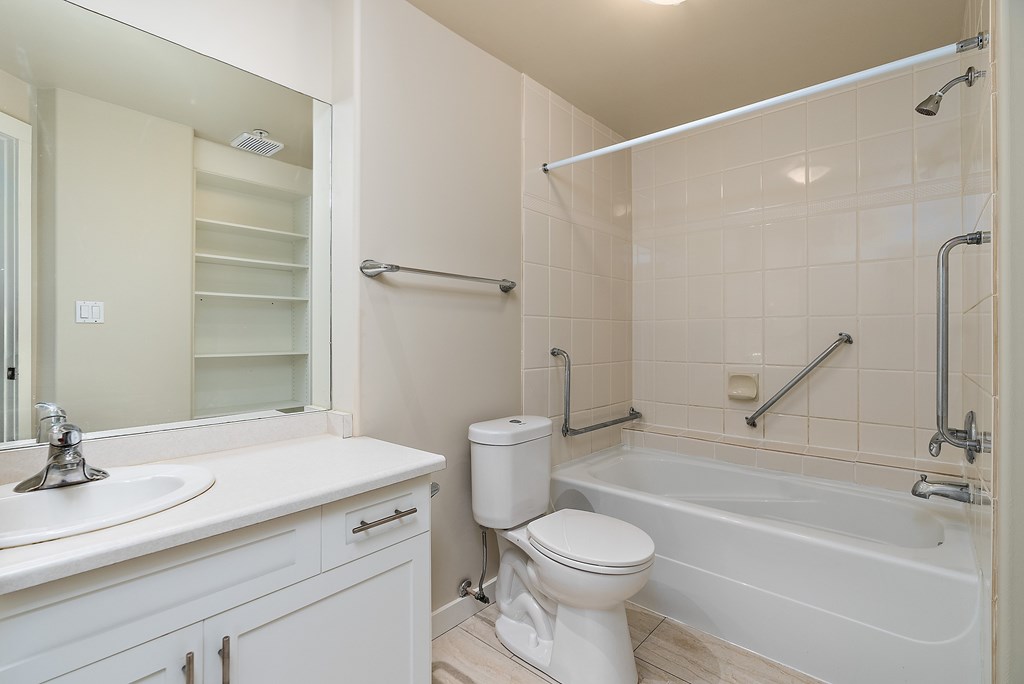 A white bathroom with a toilet, sink, and bathtub.