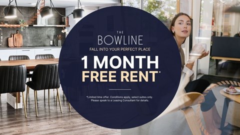 A woman is standing in a modern kitchen with a sign offering a free one month rent.