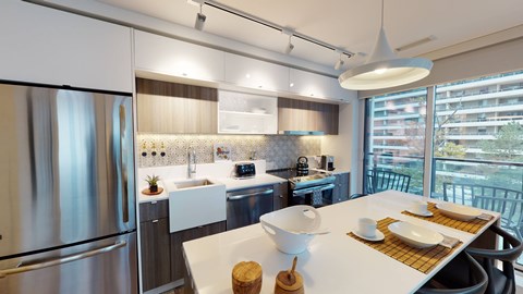 A modern kitchen with a stainless steel refrigerator and a dining table set with plates and utensils.