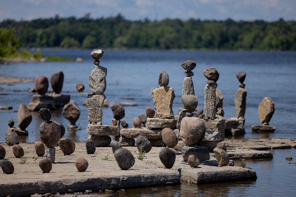 stone sculptures on a dock near a body of water