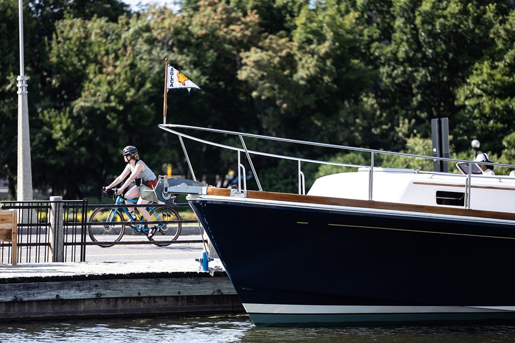 a person riding a bike on a dock next to a boat