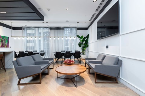 A modern living room with grey sofas and a wooden coffee table.
