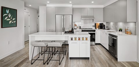 A modern kitchen with white cabinets and a large island.
