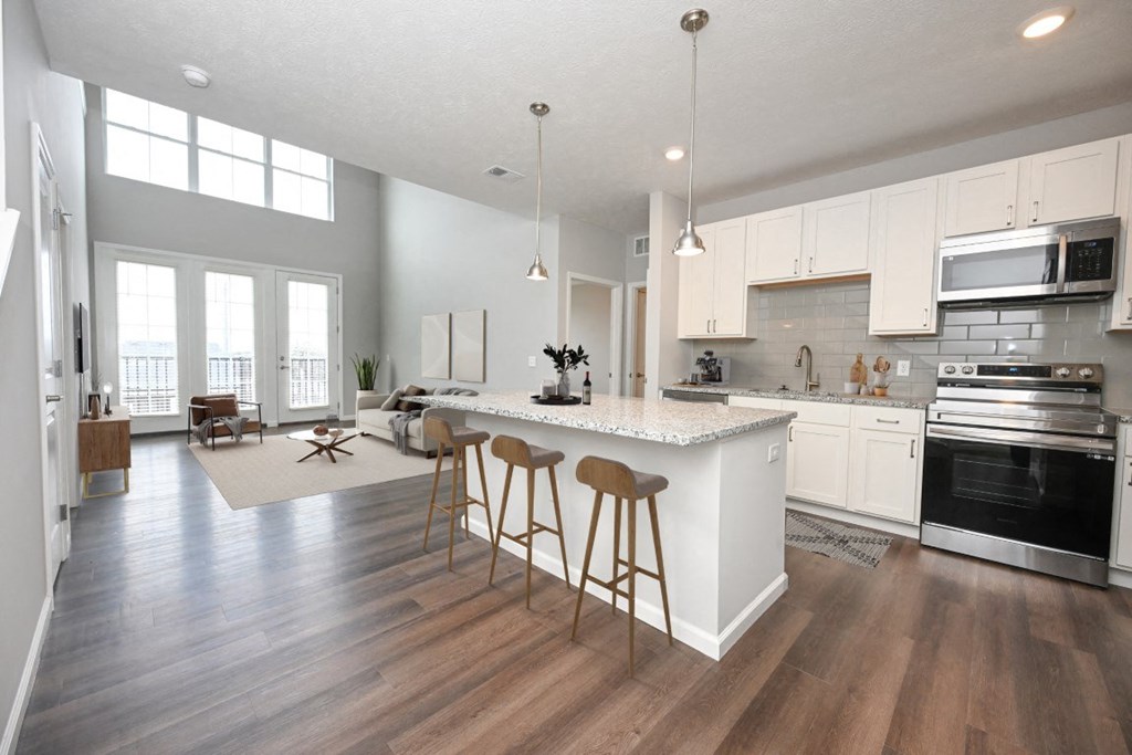 an open kitchen and living room with an island and stools at Kendall Park Too, Ohio