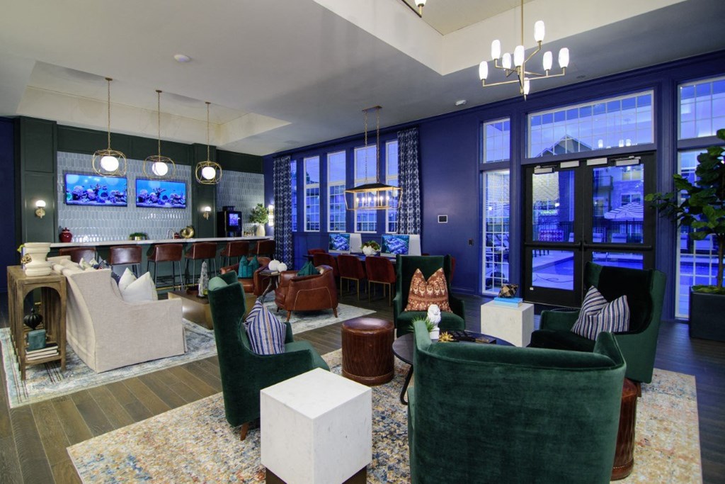 a living room with couches and chairs and a bar and large windows at Elan Park, Columbus, OH 