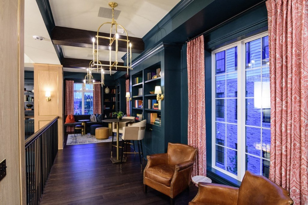 a living room with blue walls and brown leather chairs and a dining room with windows at Dalton, New Albany