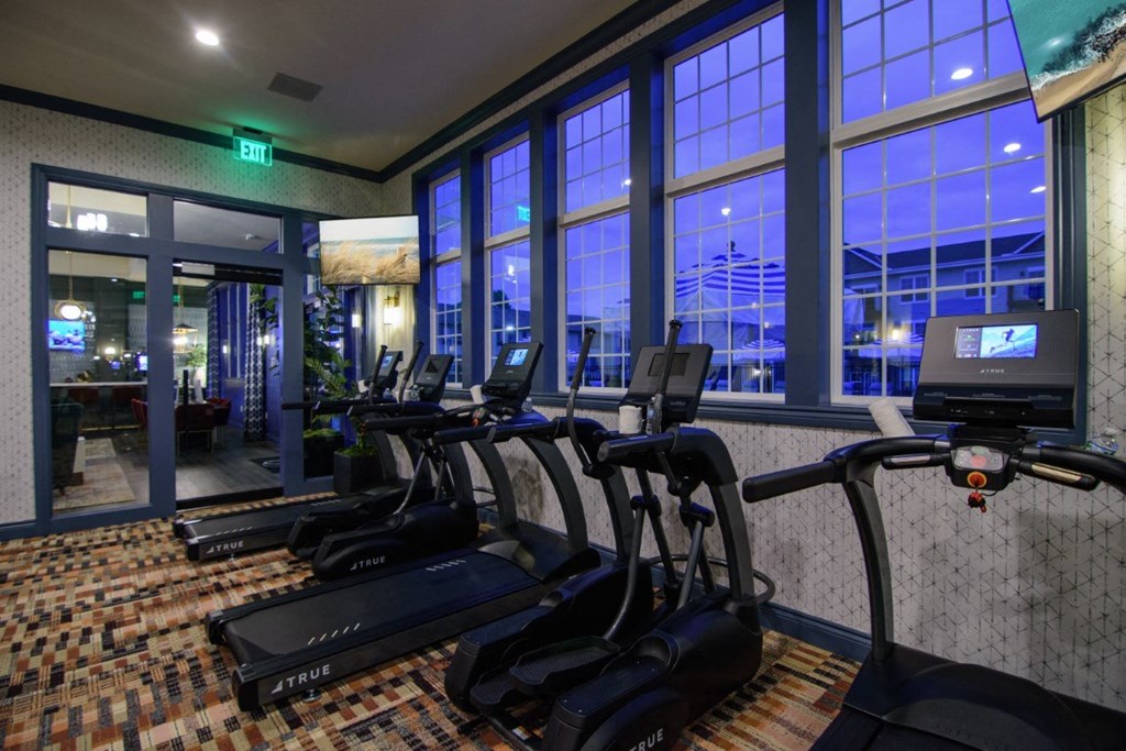a gym with cardio equipment and large windows at night at Elan Park, Columbus, OH 43231