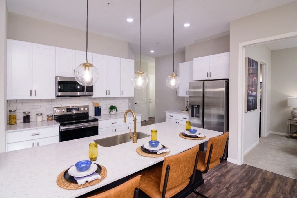 a kitchen with white cabinets and a large island with a white countertop at Essex, Columbus, OH