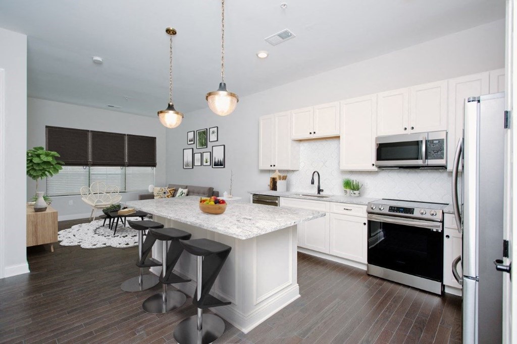 a kitchen with white cabinets and a white island with three stools at Fairfax, Grandview, OH, 43212