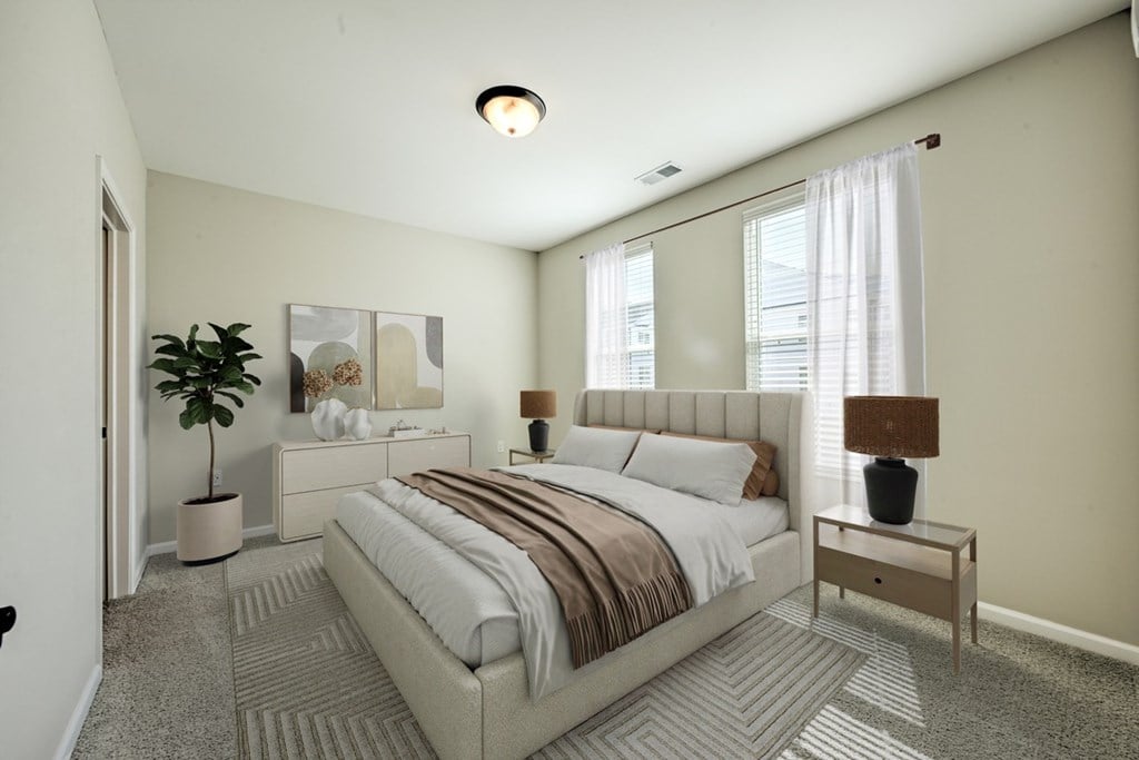 A bedroom with a large bed and a plant.