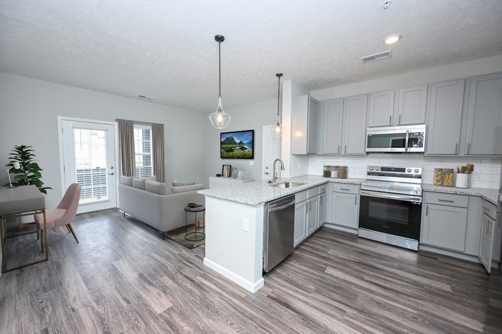 an open kitchen and living room with white cabinets at Elan Park, Ohio, 43231