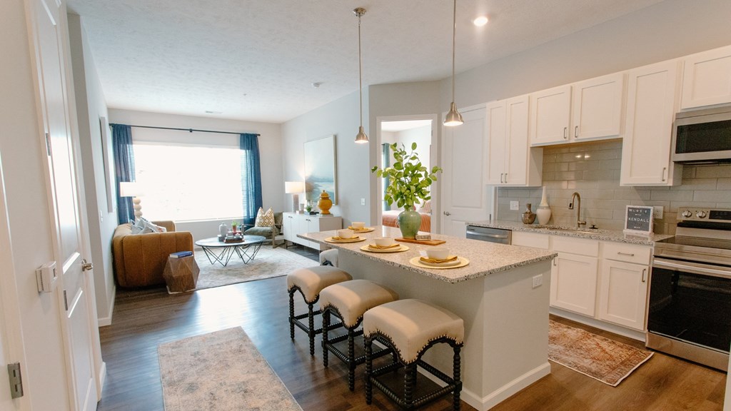a kitchen with white cabinets and a large island with a breakfast bar at Kendall Park Too, Columbus