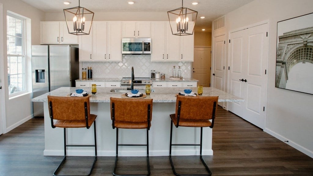 a kitchen with a large island with three chairs at Dalton, New Albany