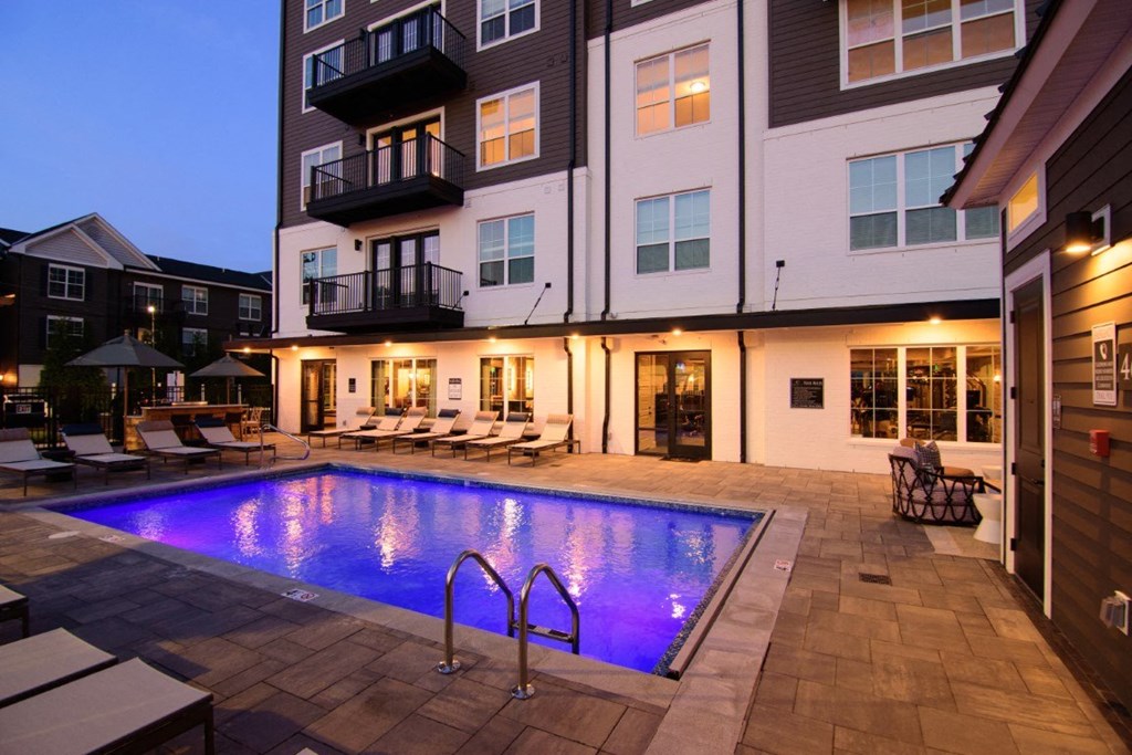 a swimming pool is lit up at night in front of an apartment building at Kendall Park, Columbus, Ohio