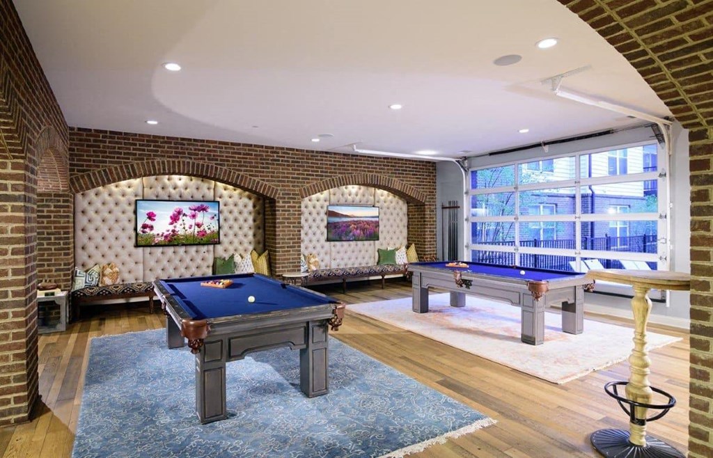 A pool table in a room with brick walls.