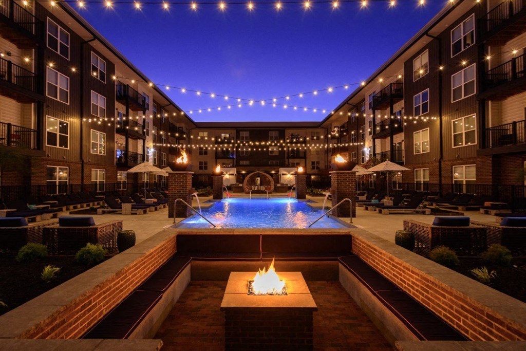 A pool with a fire pit in the middle of it.