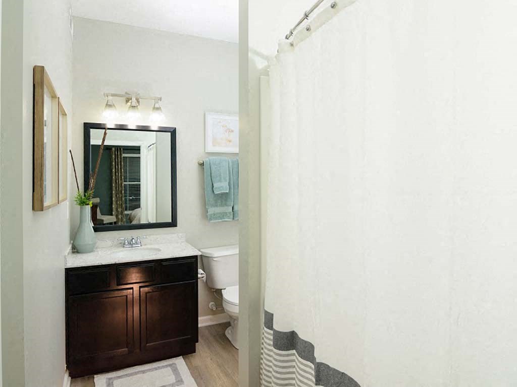 A bathroom with a white toilet and a white shower curtain.