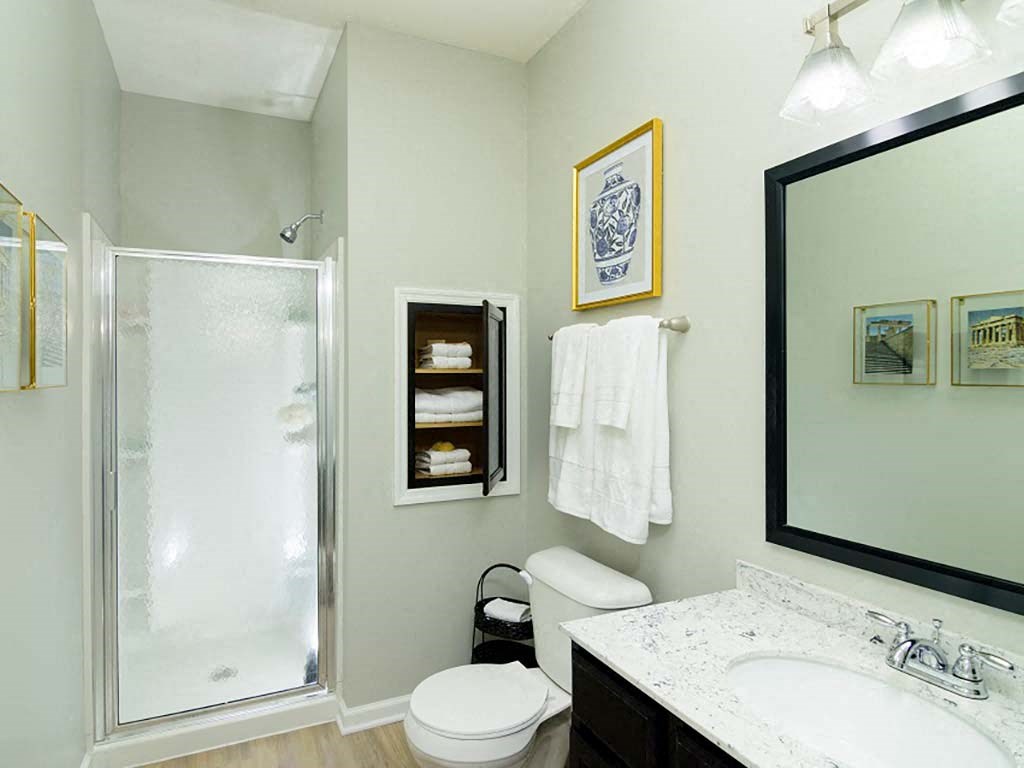 A bathroom with a toilet, sink, and shower.