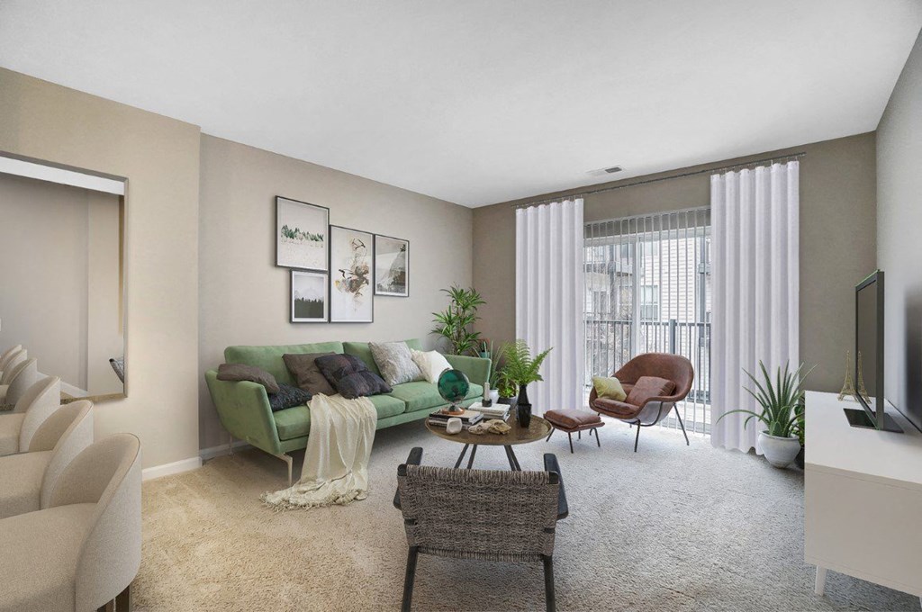 the living room of an apartment with a green couch and chairsat Taylor House Apartments, Columbus, OH