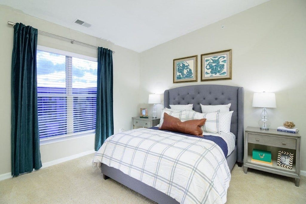 a bedroom with a large window and a bed a bedroom with a large window and a bed at Taylor House Apartments, Columbus, OH, 43214