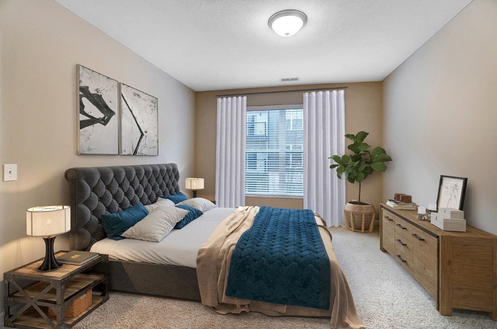 an empty bedroom with a bed and a windowat Taylor House Apartments, Ohio