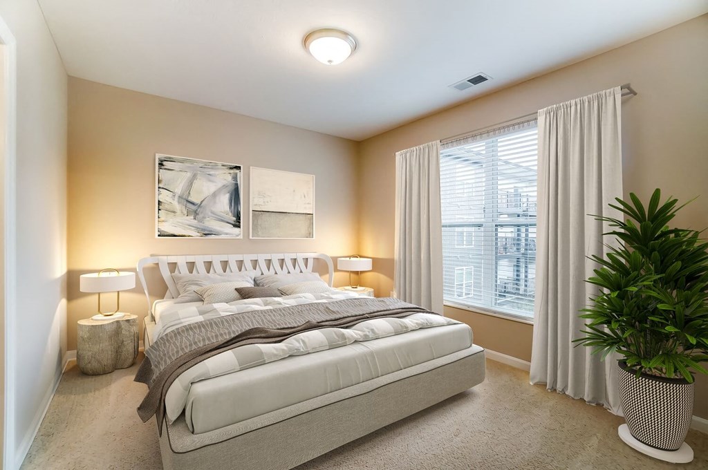 a bedroom with a bed and a potted plantat Taylor House Apartments, Columbus, OH