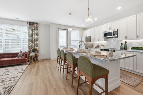 A kitchen with a table and chairs in front of it.