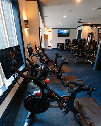 a row of exercise bikes in a room with a large window at Dalton, New Albany Ohio
