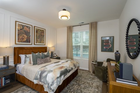 A bedroom with a large bed and a mirror on the wall.