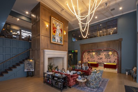 A large room with a fireplace and a painting on the wall.