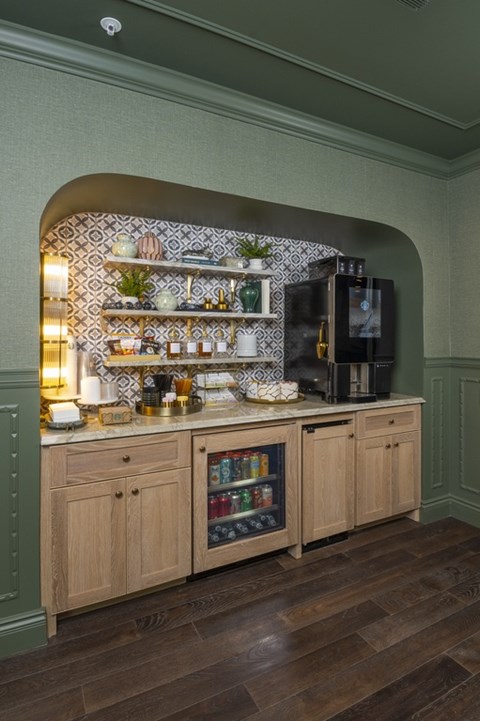 A kitchen with wooden cabinets and a green wall.