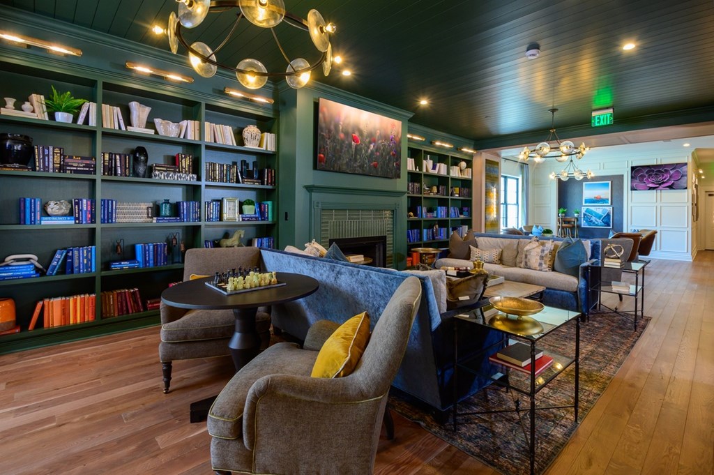 A living room with a dark wood floor and a large painting on the wall.