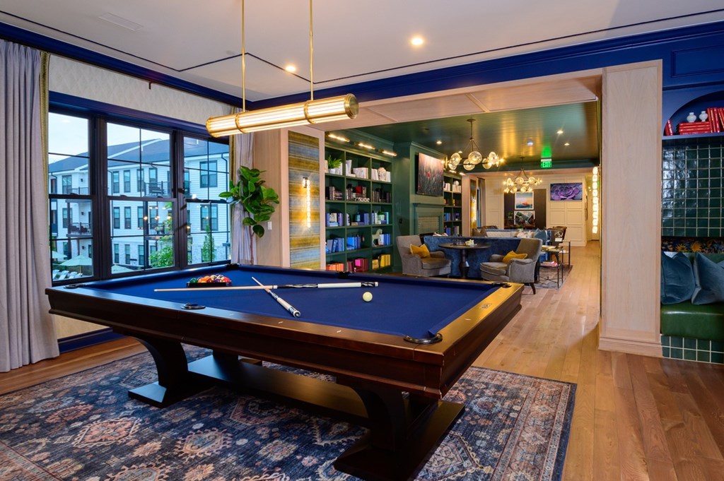 A pool table in a room with a view of the street outside.