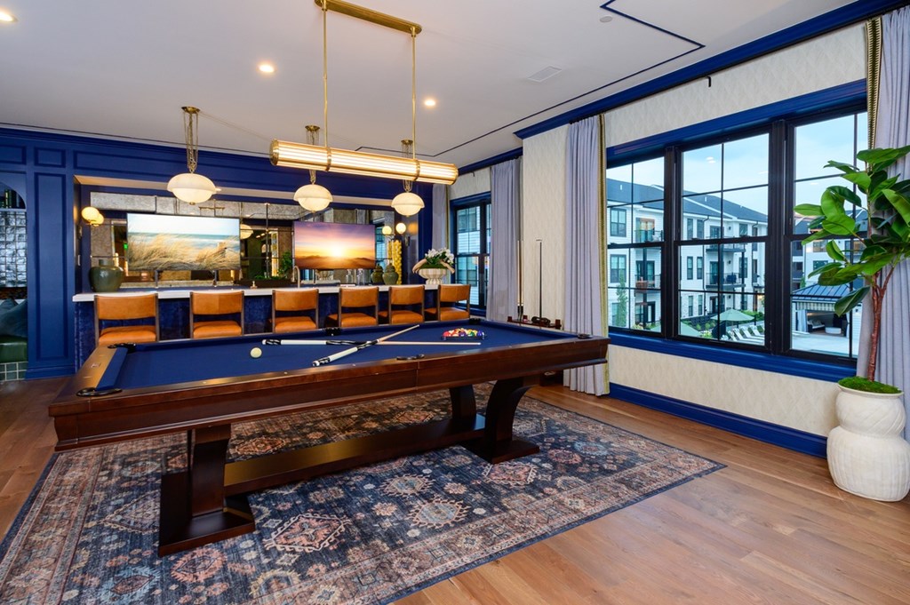 A pool table is in the middle of a room with a blue carpet.